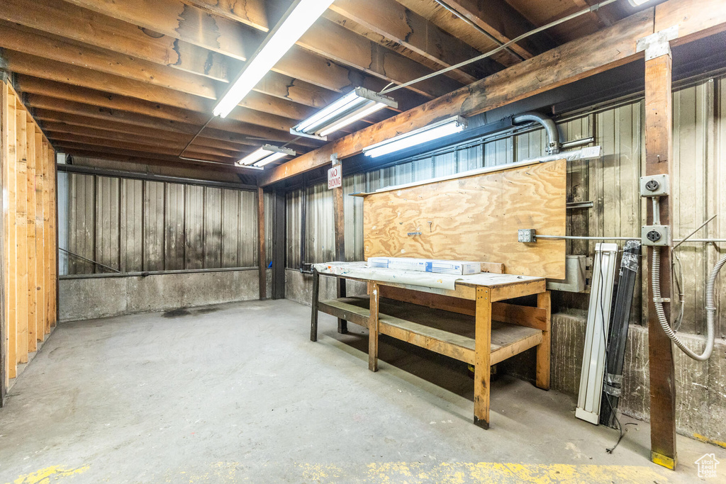 Basement featuring wooden walls and a workshop area