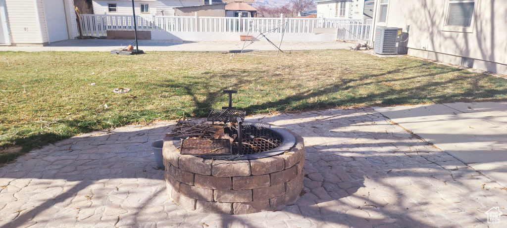 View of yard featuring an outdoor fire pit, central AC unit, and a patio
