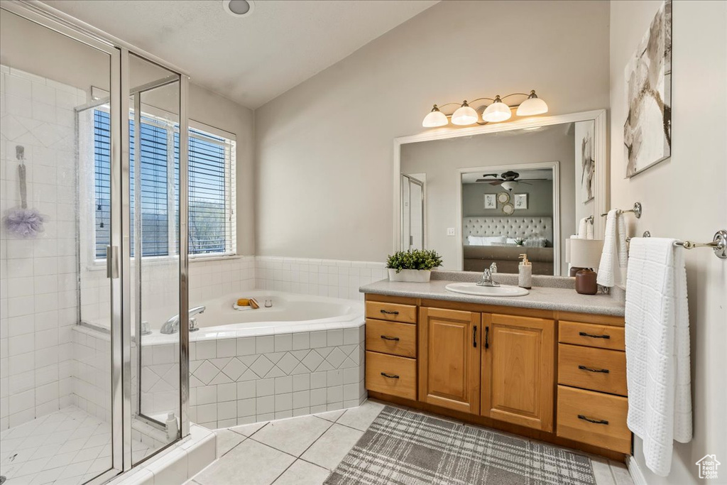 Bathroom featuring oversized vanity, ceiling fan, lofted ceiling, plus walk in shower, and tile floors