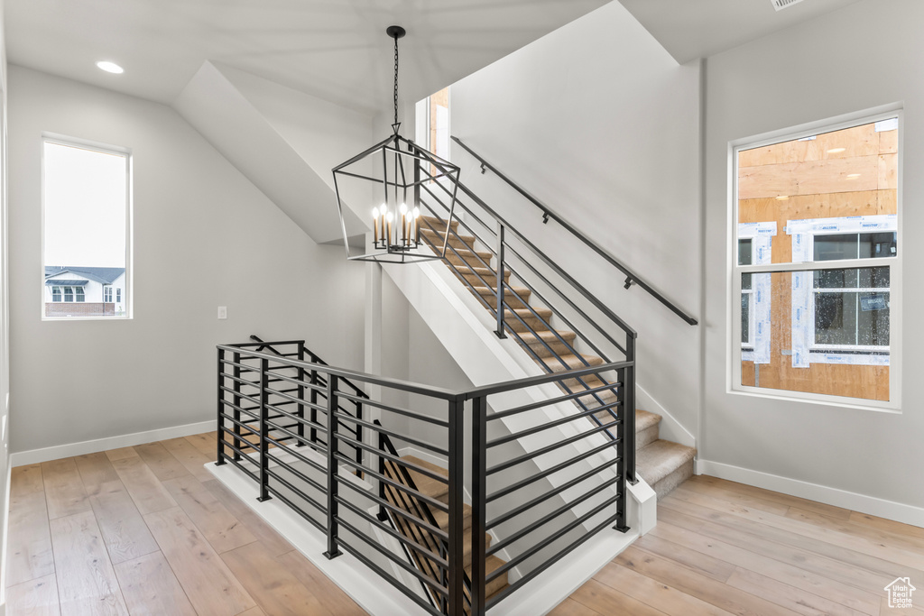 Staircase featuring a chandelier and light hardwood / wood-style flooring