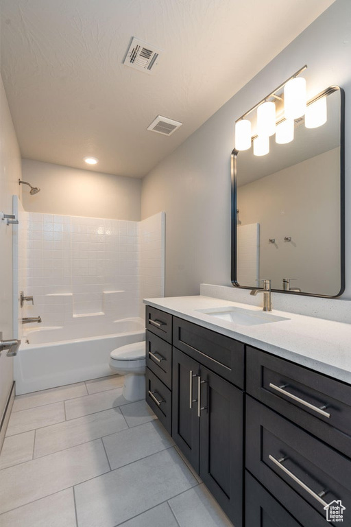 Full bathroom with tile flooring, tiled shower / bath, vanity, and toilet