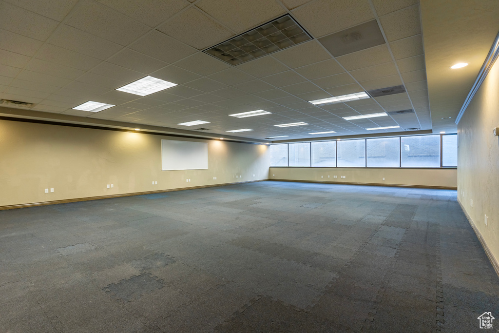 Carpeted empty room with plenty of natural light and a paneled ceiling