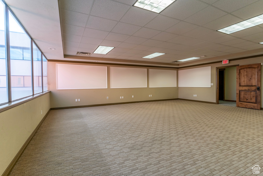 Unfurnished room featuring light colored carpet and a drop ceiling