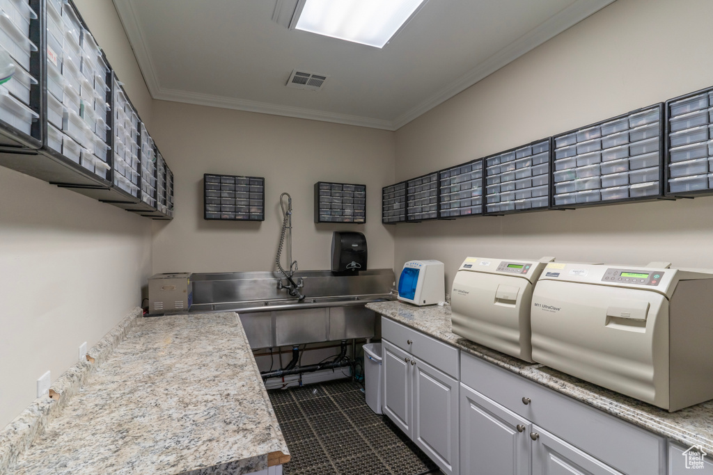 Clothes washing area with cabinets, crown molding, washer and dryer, and dark tile floors