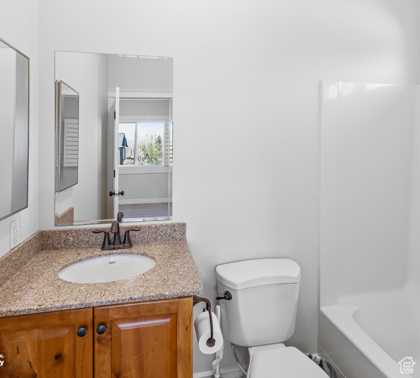 Full bathroom with washtub / shower combination, vanity, and toilet