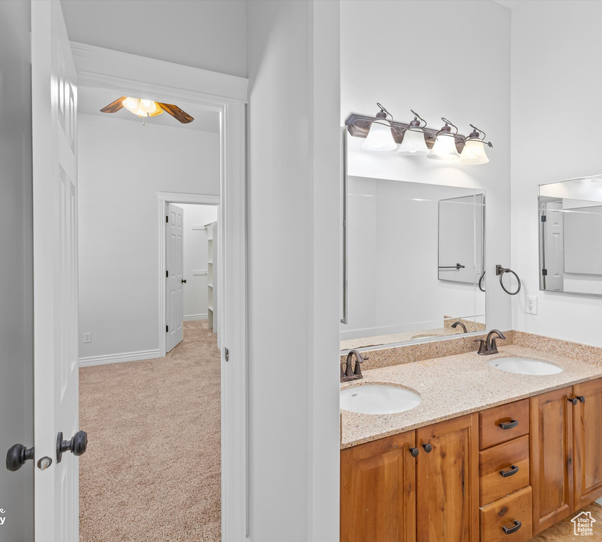 Bathroom with ceiling fan and dual vanity