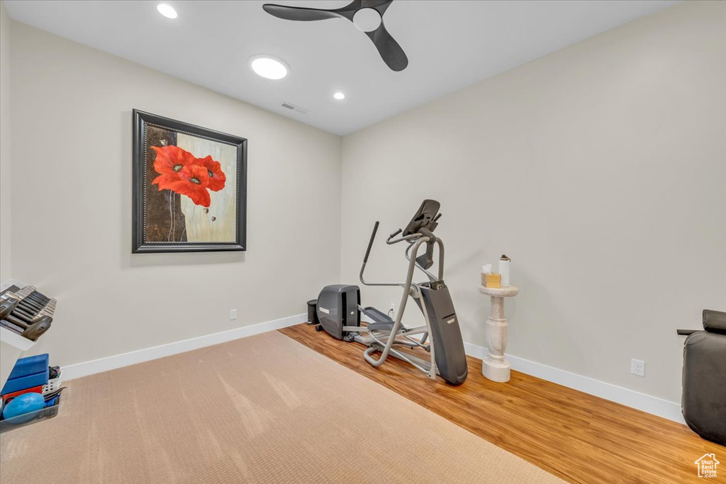Exercise room featuring light hardwood / wood-style flooring and ceiling fan