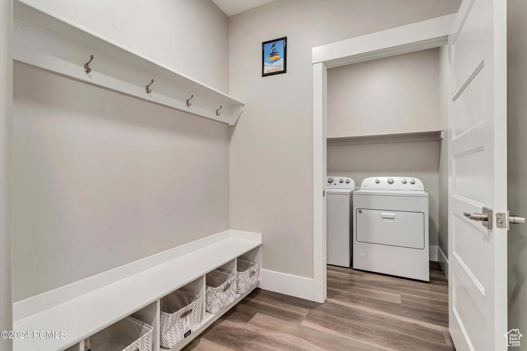 Mudroom featuring hardwood / wood-style floors and washing machine and dryer