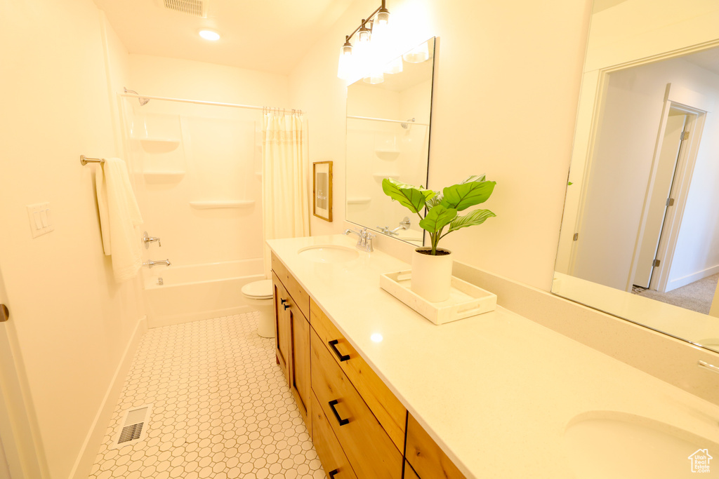 Full bathroom featuring shower / tub combo, toilet, vanity with extensive cabinet space, and tile flooring