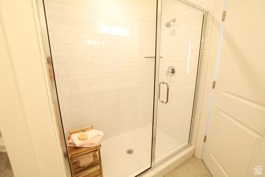 Bathroom with walk in shower, toilet, and tile flooring