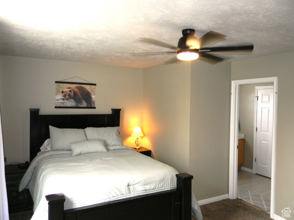 Bedroom with tile flooring, ceiling fan, and a textured ceiling
