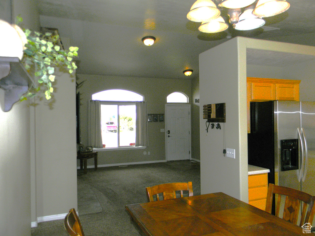Dining area with a chandelier and dark carpet