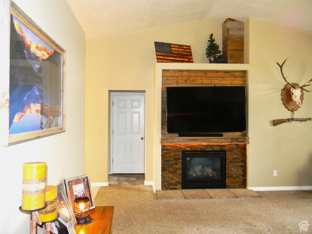Carpeted living room with lofted ceiling and a fireplace