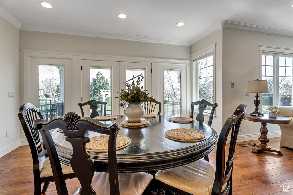 Dining room featuring ornamental molding, light hardwood / wood-style flooring, and french doors
