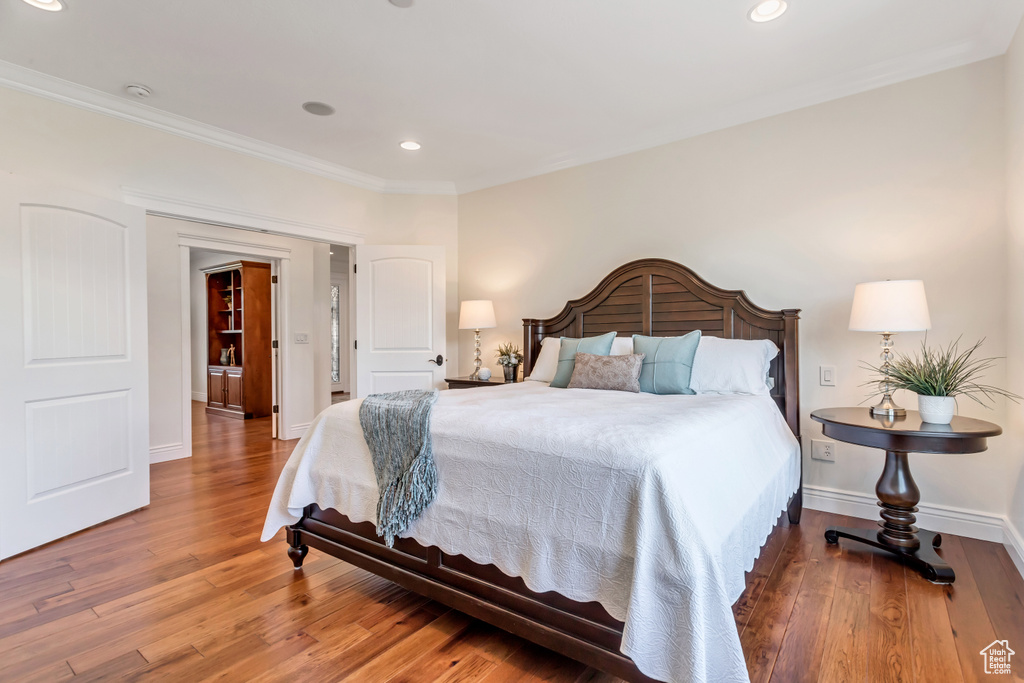Bedroom featuring crown molding and wood-type flooring