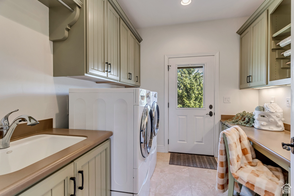 Laundry area with sink, light tile flooring, cabinets, and washing machine and clothes dryer