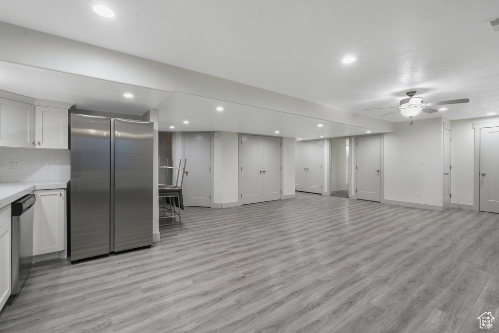 Basement featuring high end fridge, ceiling fan, and light hardwood / wood-style flooring