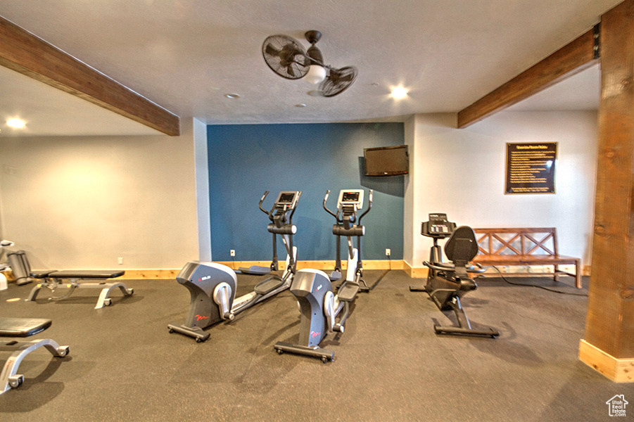 Workout area with a textured ceiling and dark colored carpet