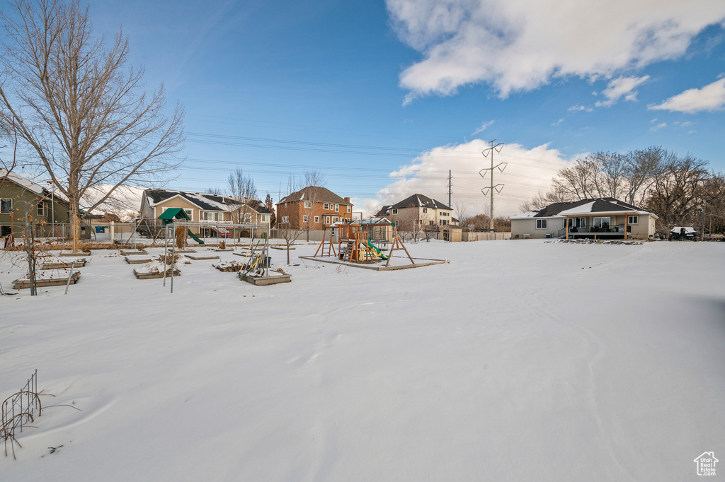 Yard covered in snow with a playground