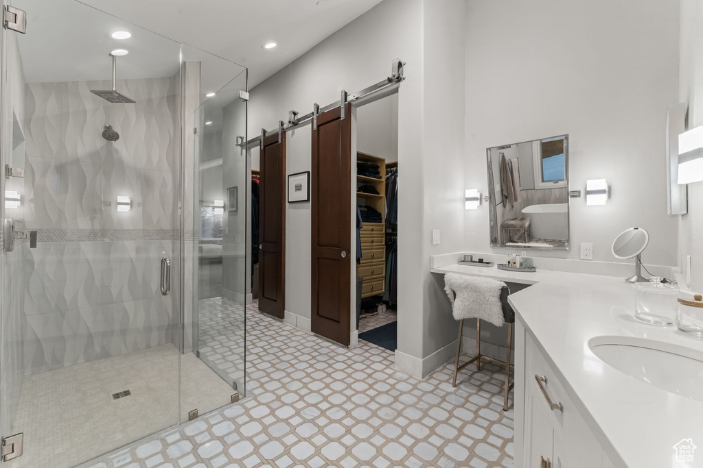 Bathroom with walk in shower, double sink vanity, and tile flooring