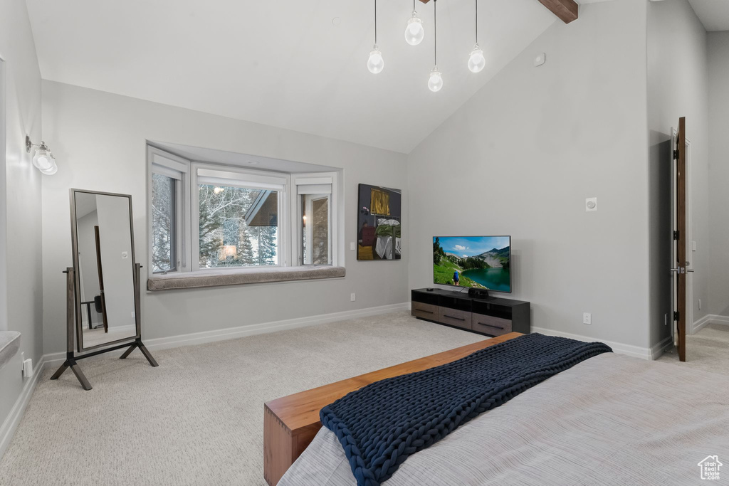 Bedroom featuring light colored carpet, beamed ceiling, and high vaulted ceiling
