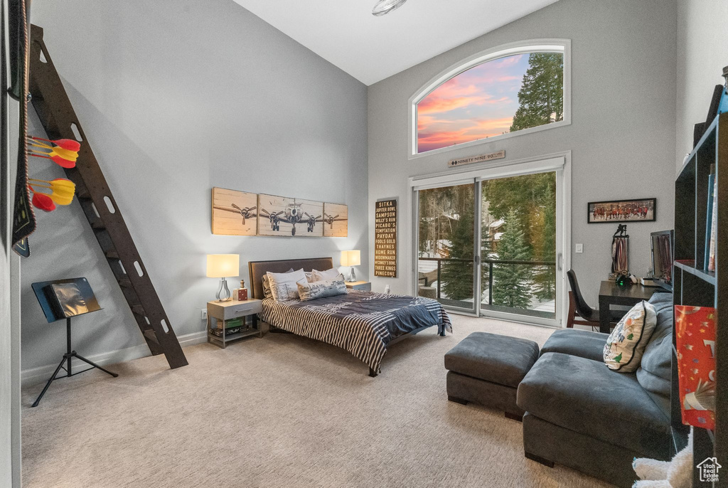 Bedroom featuring high vaulted ceiling, light carpet, and access to exterior