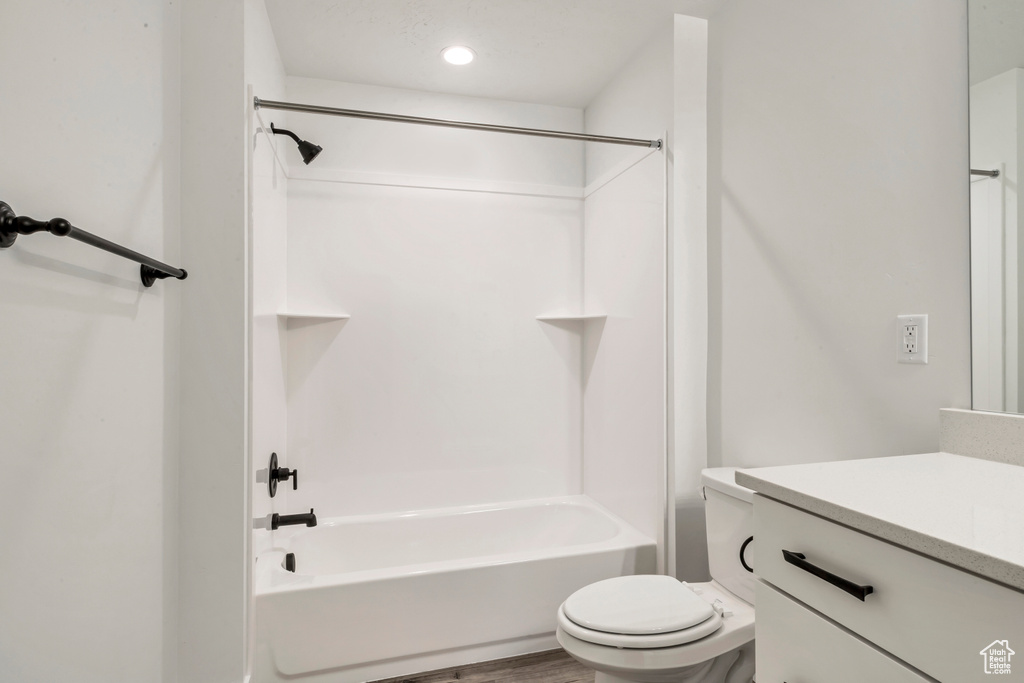 Full bathroom featuring wood-type flooring, toilet, vanity, and shower / bathtub combination