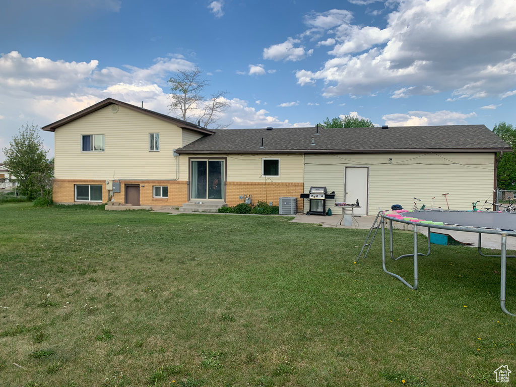 Rear view of property with a lawn and a patio area
