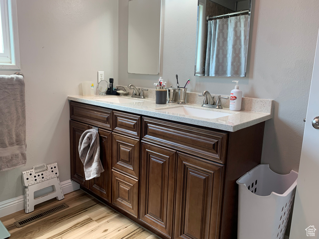 Bathroom featuring hardwood / wood-style floors, dual sinks, and large vanity