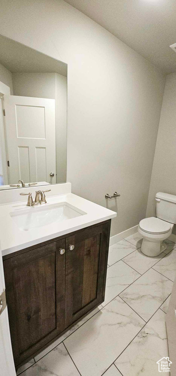 Bathroom featuring vanity, toilet, and tile flooring