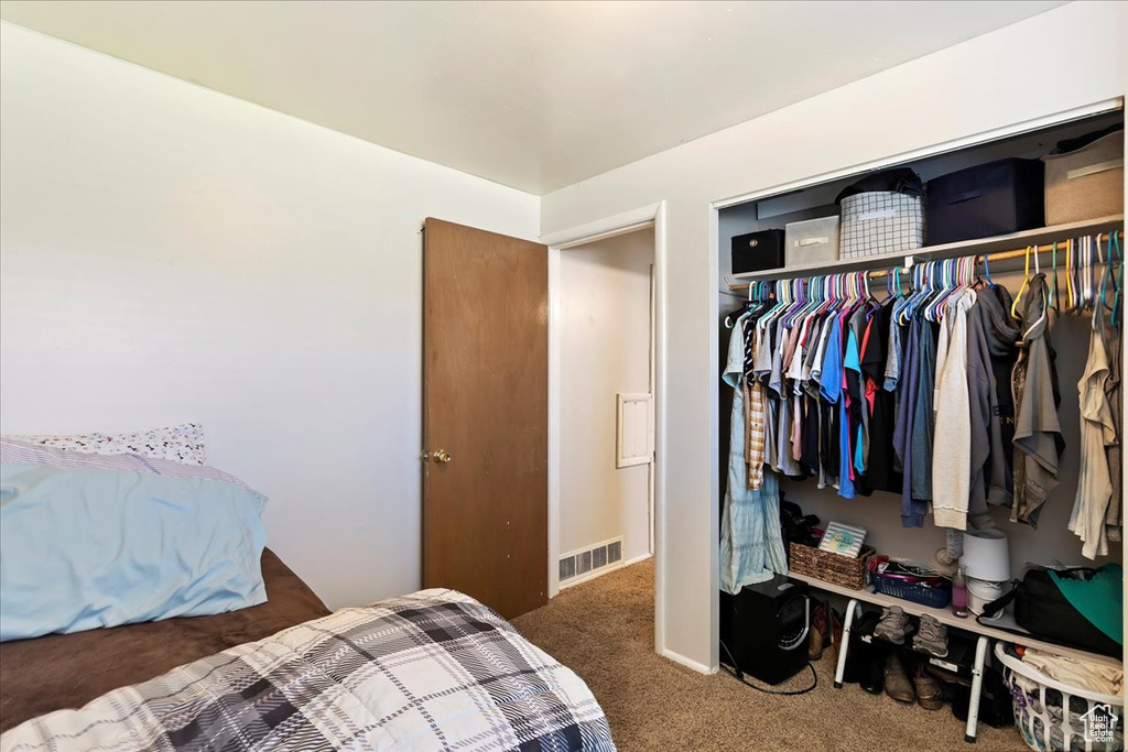Bedroom featuring a closet and dark colored carpet