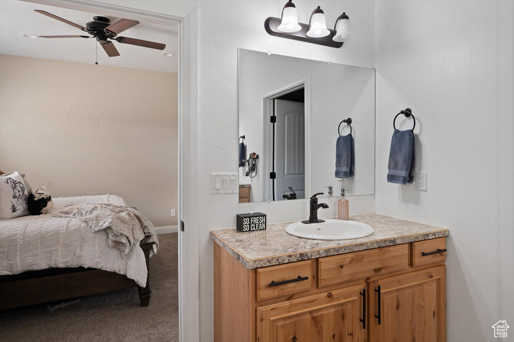 Bedroom featuring carpet floors, ceiling fan, and sink