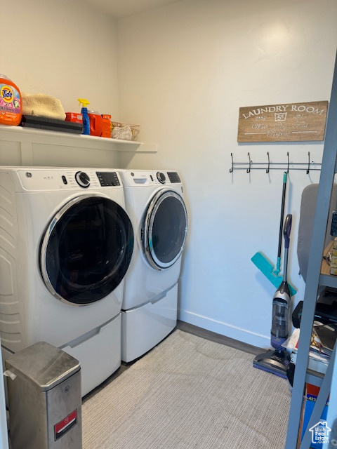 Laundry area with light colored carpet and separate washer and dryer