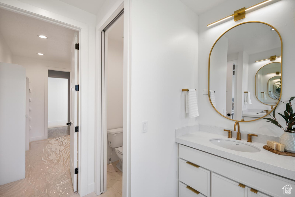 Bathroom featuring tile floors, toilet, and large vanity