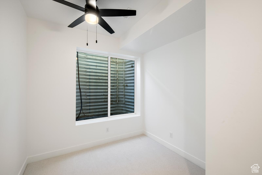 Carpeted spare room with ceiling fan