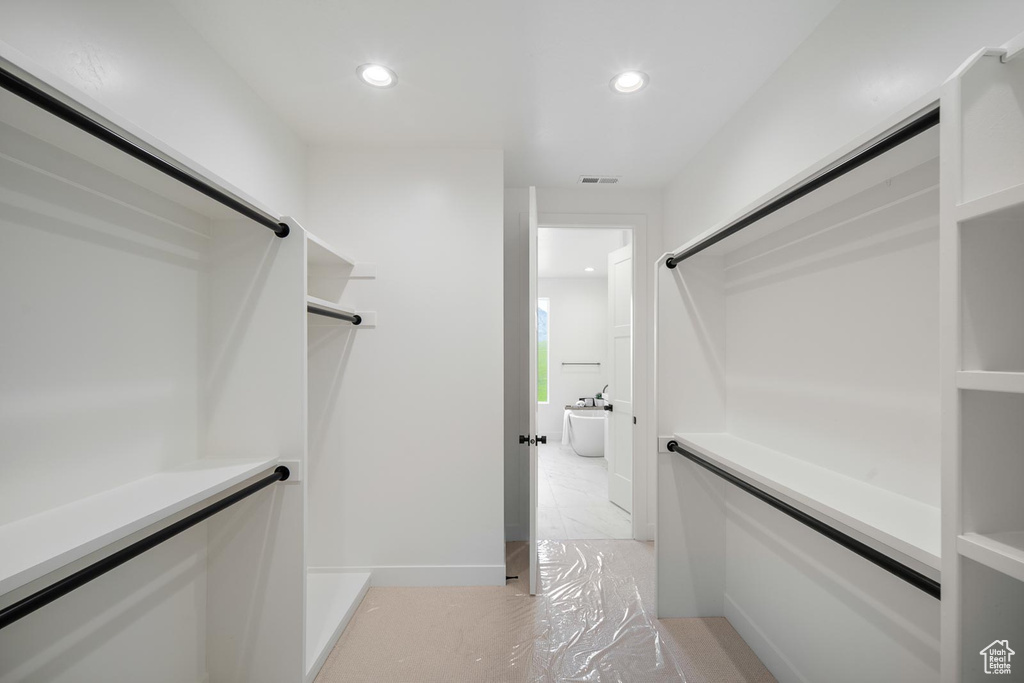 Walk in closet featuring light tile floors