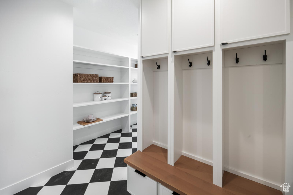 Mudroom with dark tile floors