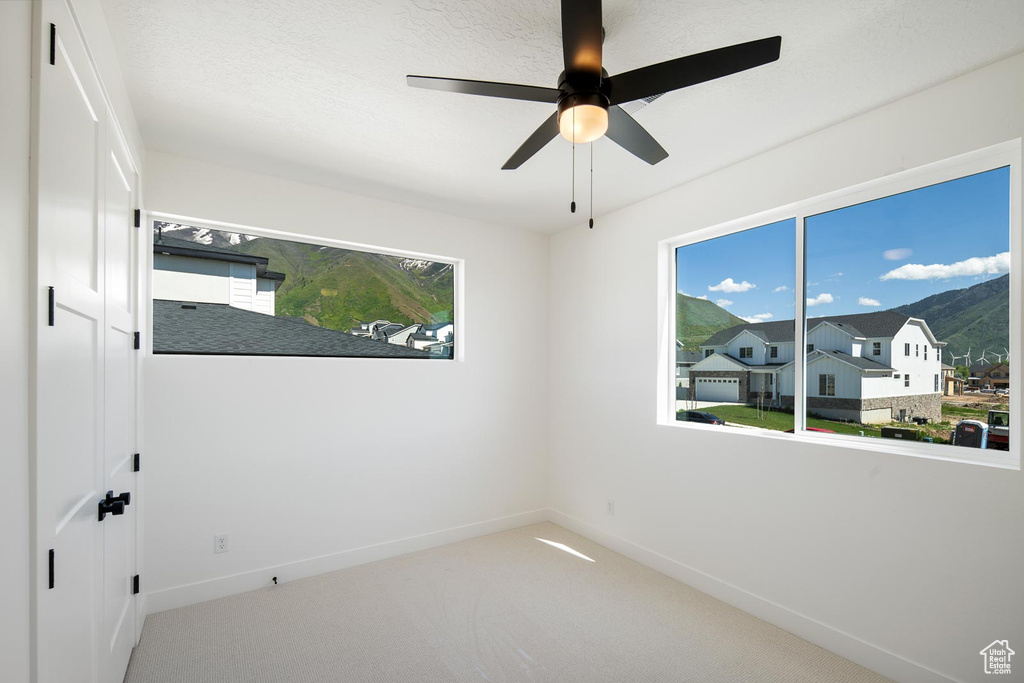 Unfurnished room featuring carpet and ceiling fan