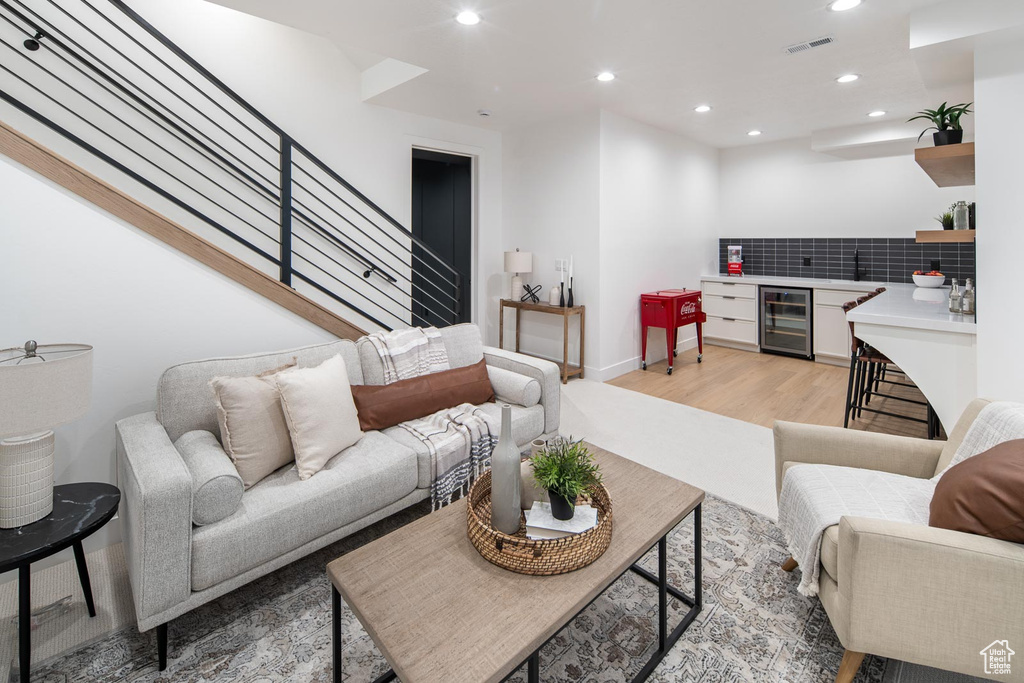 Living room with light wood-type flooring and beverage cooler