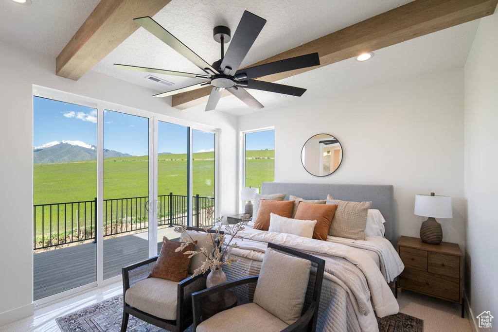 Bedroom featuring beam ceiling, a mountain view, ceiling fan, and access to outside