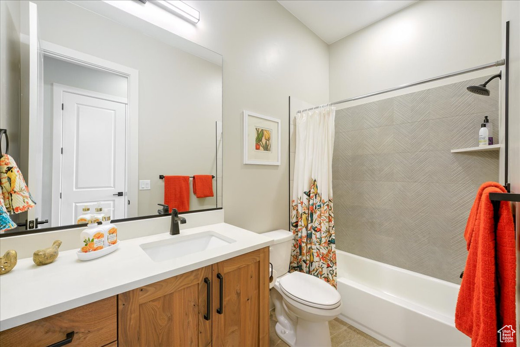 Full bathroom featuring shower / tub combo with curtain, oversized vanity, toilet, and tile flooring