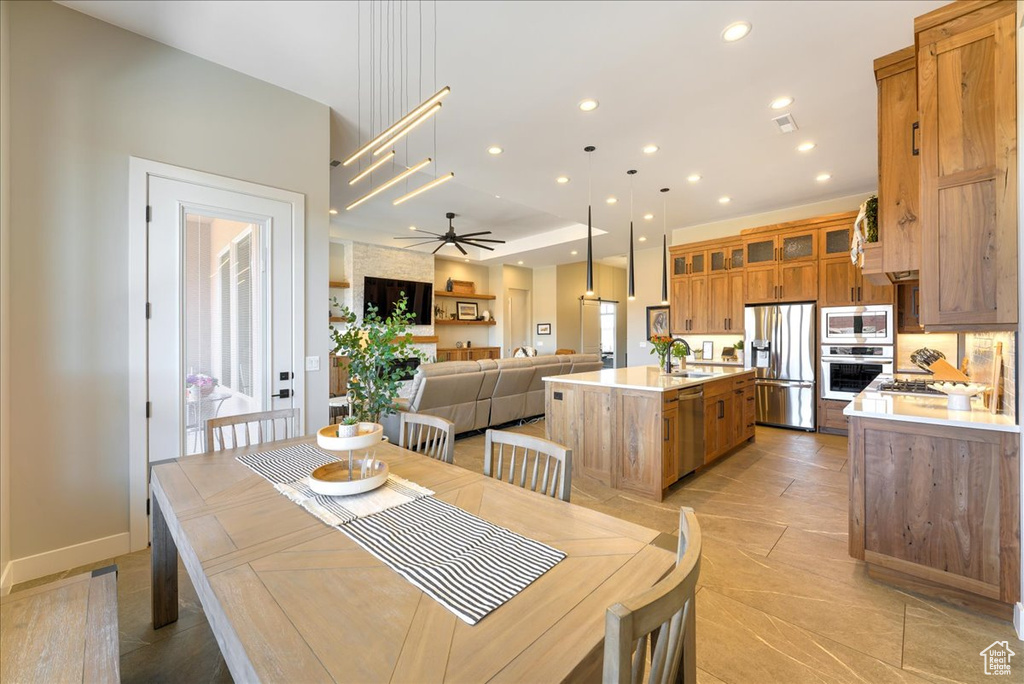 Dining area featuring light tile floors, ceiling fan, and sink