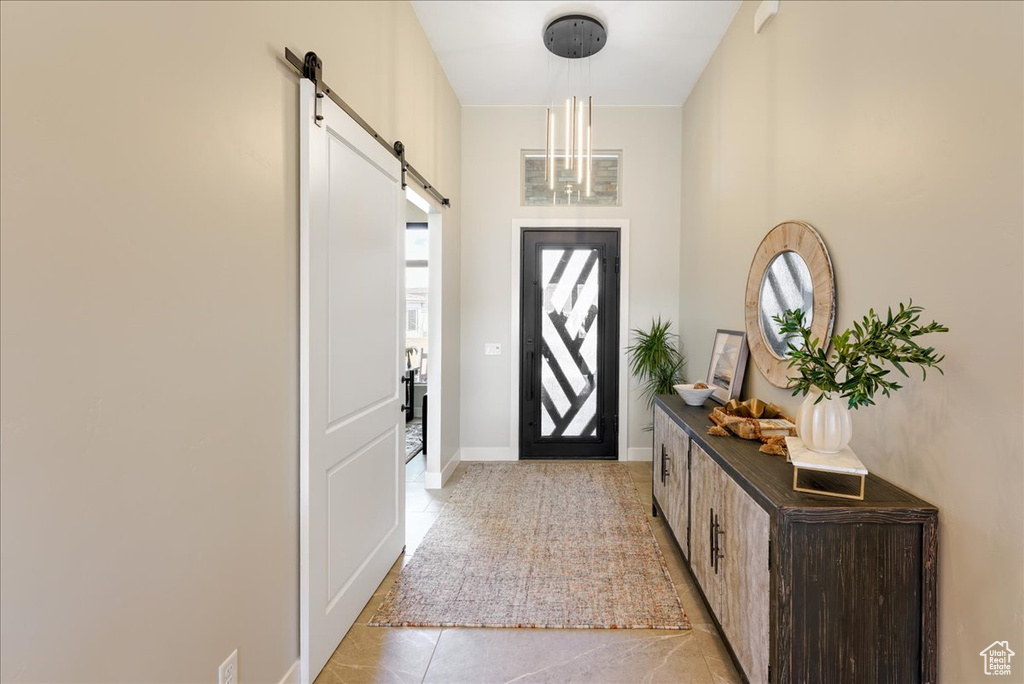 Tiled entryway featuring plenty of natural light and a barn door