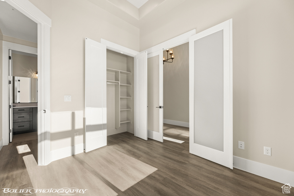 Unfurnished bedroom with dark hardwood / wood-style flooring and a closet