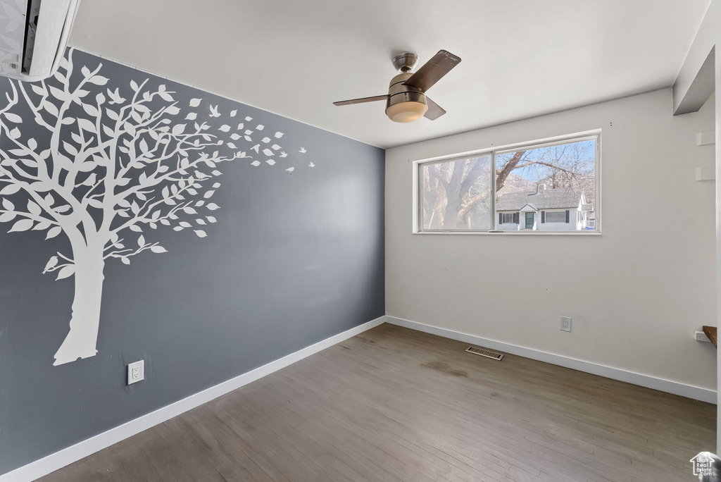 Empty room featuring ceiling fan and hardwood / wood-style flooring