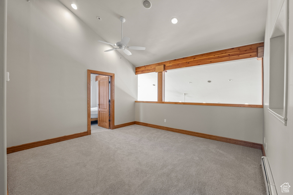 Carpeted spare room with high vaulted ceiling, ceiling fan, and baseboard heating