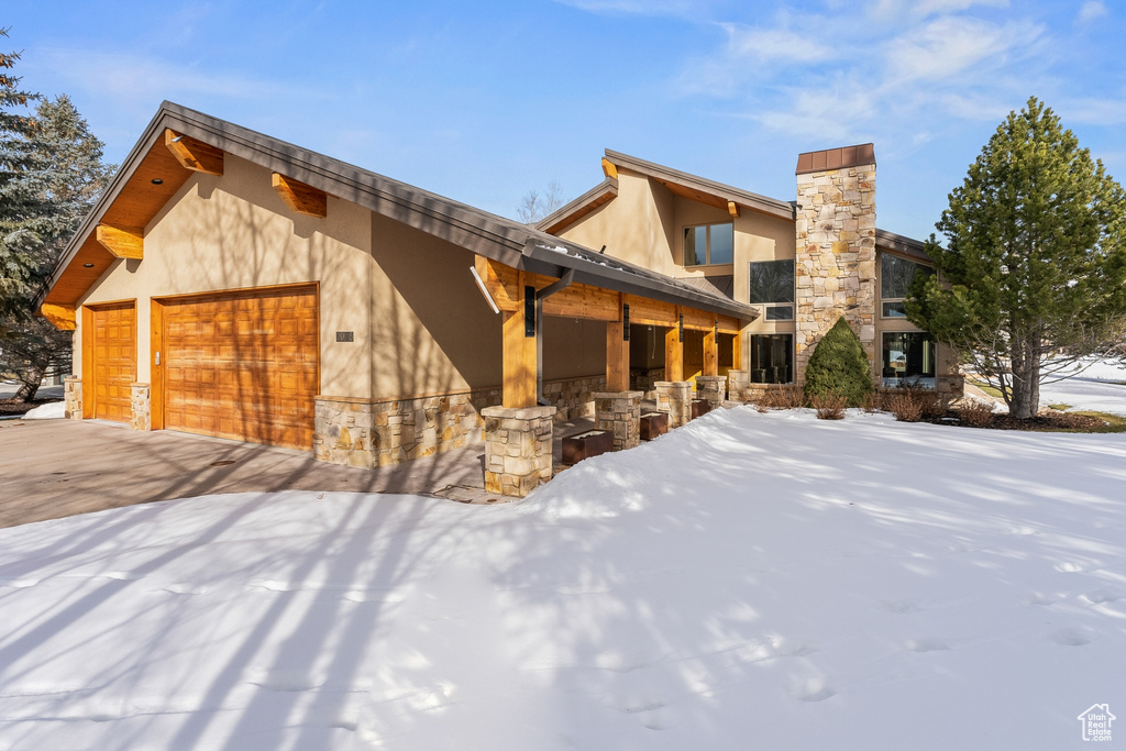 Snow covered property with a garage