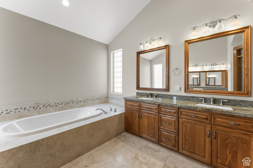 Bathroom featuring dual bowl vanity, a relaxing tiled bath, tile floors, and vaulted ceiling