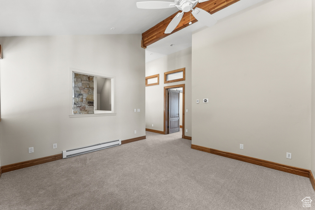 Carpeted empty room with high vaulted ceiling, ceiling fan, a baseboard radiator, and beam ceiling