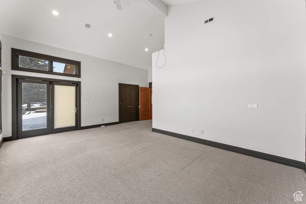 Unfurnished room with light carpet and a high ceiling